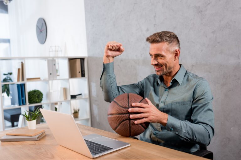 cheerful-businessman-holding-basketball-while-watc-2022-11-03-19-32-55-utc